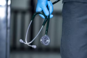 A person holding a stethoscope to represent healthcare.