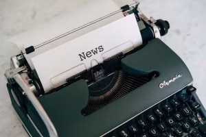 A page in a typewriter with news on it.
