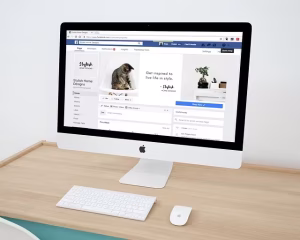 An Apple computer with a Facebook page on it for social media.