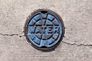 A manhole cover with water on it for water resource management.