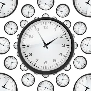 A clock surrounded by smaller clocks on a white background.